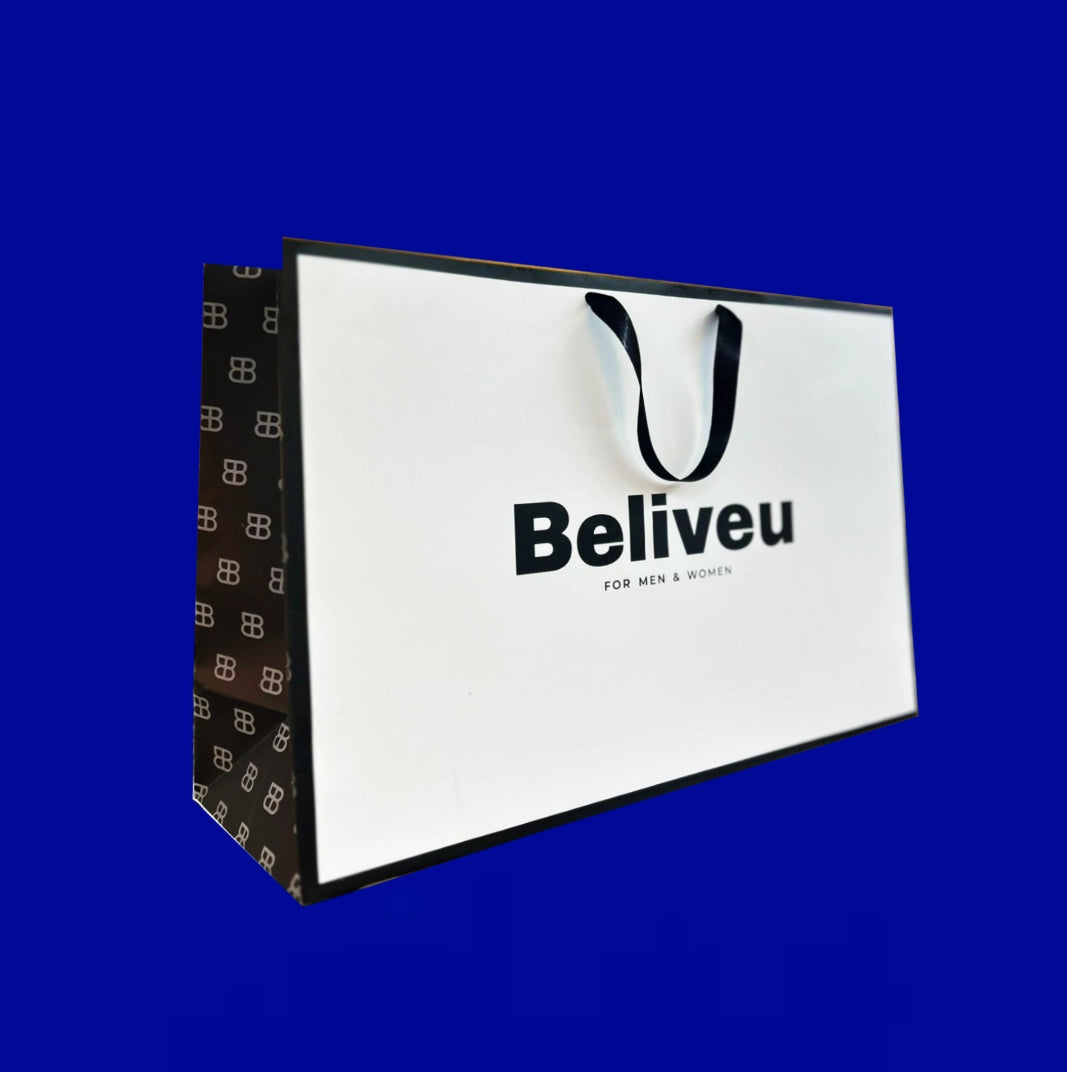 Bolsa premium blanca con cinta negra y logo en negro, sostenida en mano