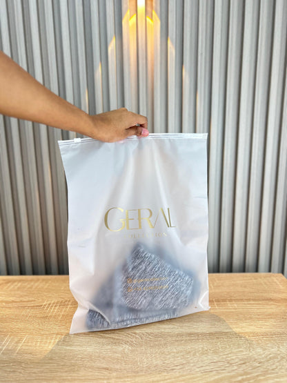 Bolsa de vinilo esmerilado con cierre y logo dorado de boutique, montaje de catálogo