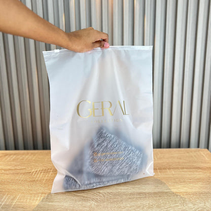 Bolsas de vinilo esmerilado con cierre y logo dorado, en el taller