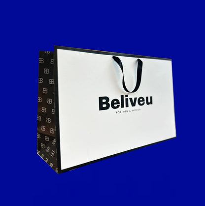 Bolsa premium blanca con cinta negra y logo en negro, sostenida en mano